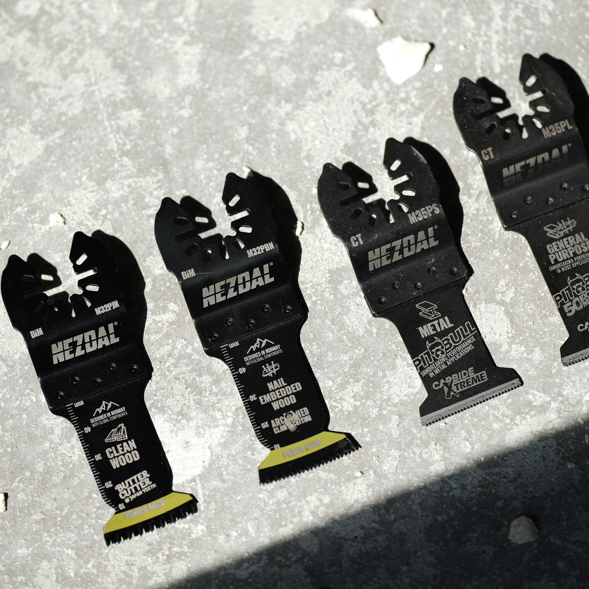 4 multi-tool blades on a concrete surface